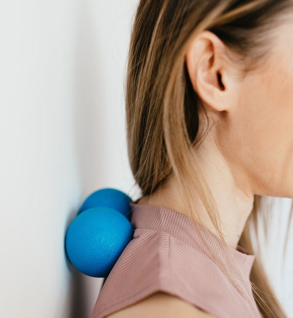 Woman performing a gentle neck stretch as part of her wellness routine.